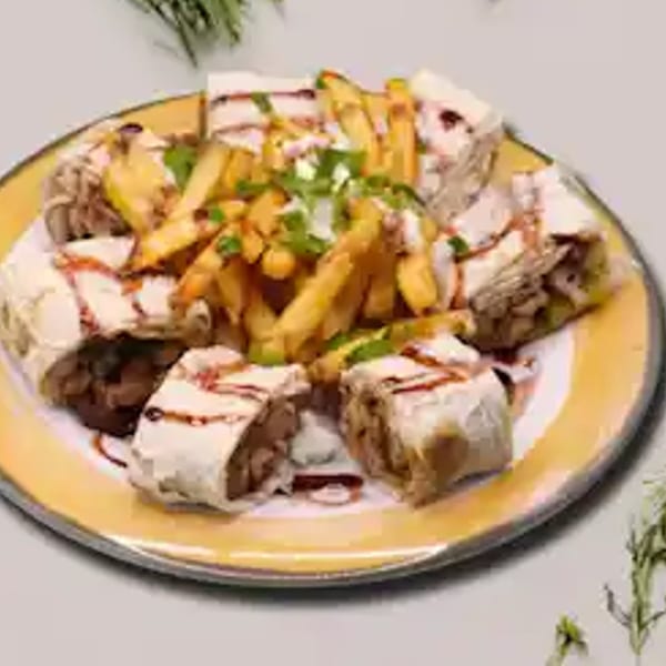 Turkish doner wraps with french fries, drizzled with sauce and garnished with herbs on a yellow plate.